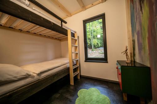 een slaapkamer met een stapelbed en een raam bij Forest Garden Family 
