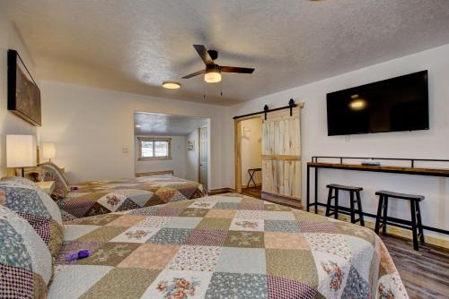 a bedroom with two beds and a flat screen tv at Alpine Lodge Hotel in Cascade