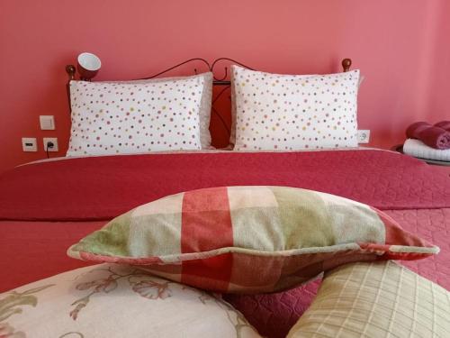 een slaapkamer met een bed met rode lakens en kussens bij ViNCENT - Central 2 Bedroom Apartment 79sqm in Tripolis