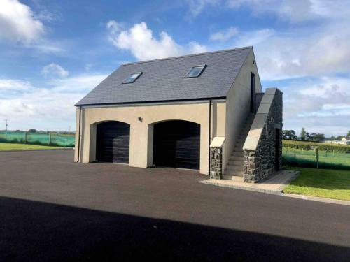 a large garage with two garage doors and a sky at Lily’s Loft Bushmills in Bushmills