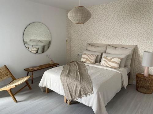 a bedroom with a bed and a mirror and a chair at AD apartment in La Oliva