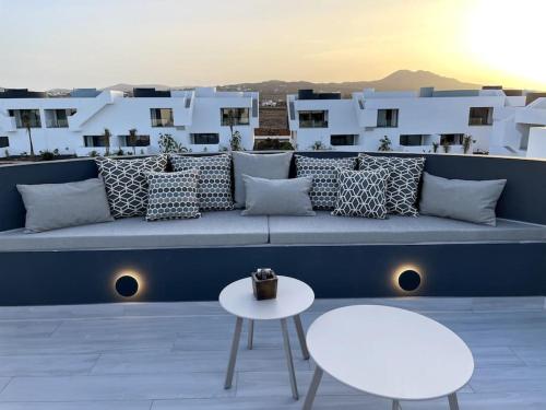 a couch on a rooftop with a table and chairs at AD apartment in La Oliva