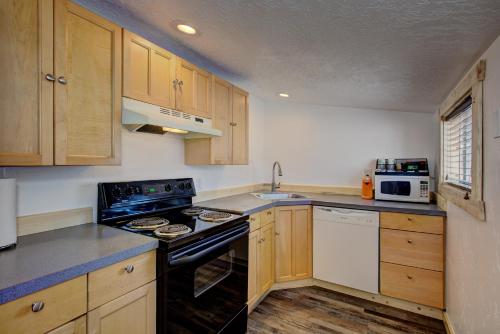 a kitchen with wooden cabinets and a black stove top oven at Alpine Lodge Hotel in Cascade