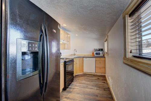 a small kitchen with a refrigerator and a sink at Alpine Lodge Hotel in Cascade