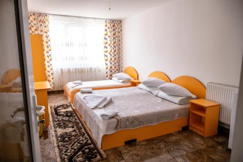 a small bedroom with two beds and a window at Pensiunea Larisa in Ocna Şugatag