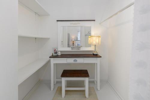 a bathroom with a vanity with a mirror and a stool at Golf Beach and Sea in Southbroom