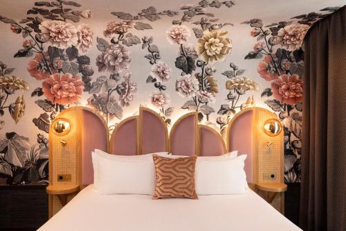 a bedroom with a bed with a floral wallpaper at Hôtel Jardin de Cluny in Paris