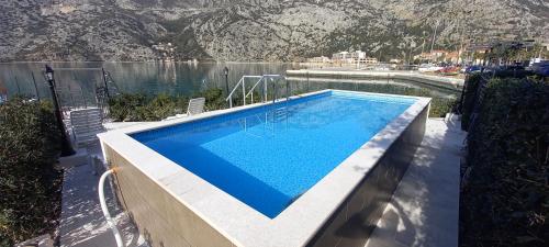 a swimming pool next to a body of water at Villa Ivan in Risan
