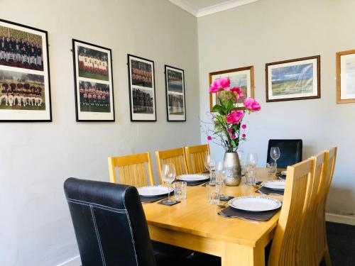a wooden table with chairs and a vase with flowers at Bonnygate in Fife