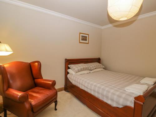 a bedroom with a bed and a chair at Little Foxes in Calne