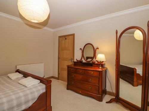 a bedroom with a bed and a mirror and a dresser at Little Foxes in Calne