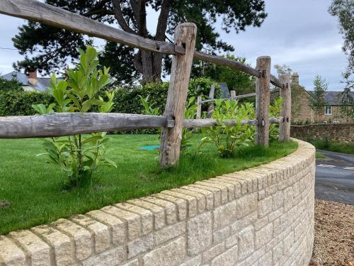 a wooden fence in front of a brick wall at Little Foxes in Calne