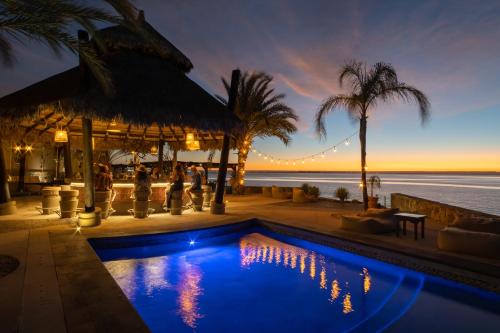 a resort pool with a view of the ocean at Orchid House Baja in La Paz