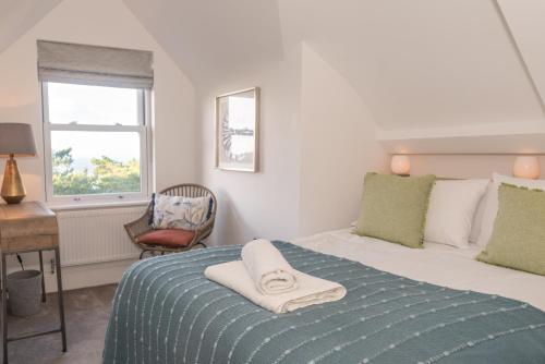 a bedroom with a bed with a towel on it at Larkrise Penthouse Apartment in Woolacombe