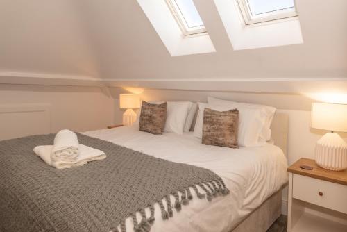 a bedroom with a bed with white sheets and pillows at Larkrise Penthouse Apartment in Woolacombe