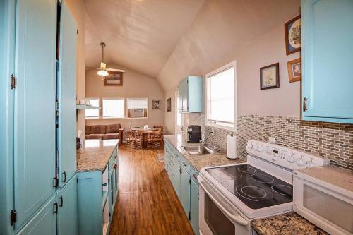 La cuisine est équipée de placards bleus et d'un four avec plaques de cuisson. dans l'établissement Palo Duro Canyon Texas - Cowboy Cabin, à Canyon