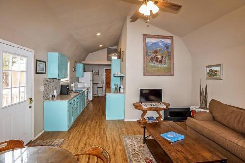 a living room with a couch and a kitchen with blue cabinets at Palo Duro Canyon Texas - Cowboy Cabin in Canyon