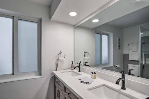a bathroom with a sink and a large mirror at Whitecaps Beach house in Delray Beach