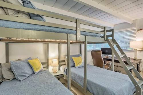 a bedroom with two bunk beds and a desk at Whitecaps Beach house in Delray Beach