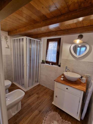 een badkamer met een wastafel, een toilet en een spiegel bij Casa Toscana in Lorenzana
