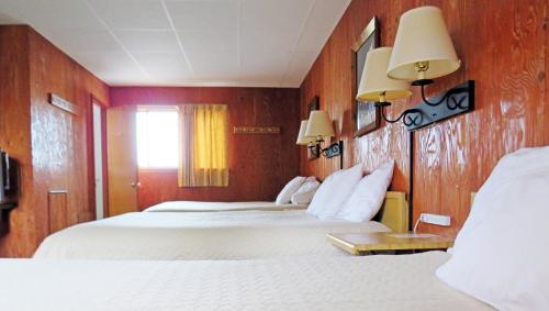 Habitación de hotel con 2 camas y 2 lámparas en Indianhead Ironwood Hotel en Ironwood