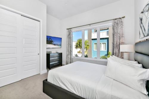 a white bedroom with a large bed and a window at Spacious Condo near Disney w/ Hotel Amenities - 7770 - 27 - 212 in Kissimmee