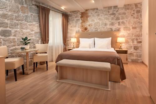 um quarto de hotel com uma cama, uma mesa e cadeiras em Lanterna Rooms em Split