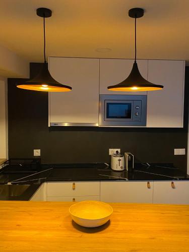 a kitchen with two lights and a bowl on a wooden table at Rio D´Sal in Alcochete