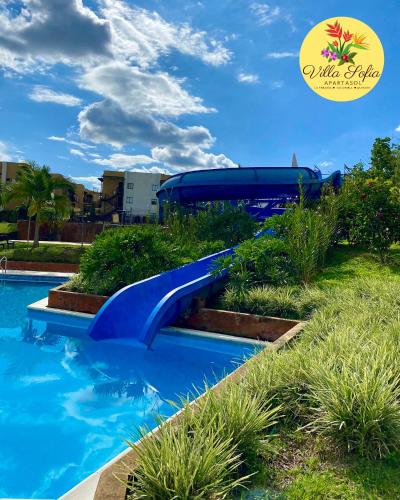 a blue water slide in a resort swimming pool at Apartasol Villa Sofia, Reserva de la Colina, La Tebaida, Quindio in La Tebaida