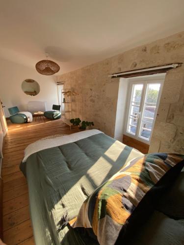 a bedroom with a large bed and a window at Le Clos des Grands Frênes in Pons