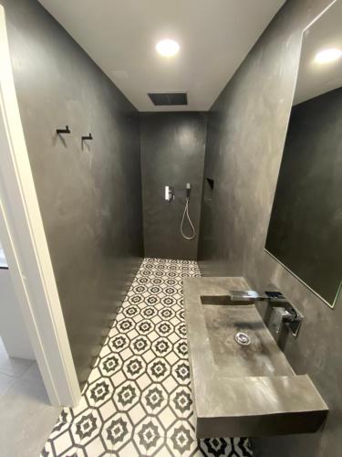 ein Bad mit einem Waschbecken und Fliesenboden in der Unterkunft Rio D´Sal in Alcochete