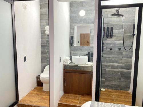La salle de bains est pourvue d'une douche, de toilettes et d'un lavabo. dans l'établissement Suites del Barrio, à San Cristóbal de Las Casas