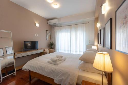 ein Schlafzimmer mit einem großen Bett mit Handtüchern darauf in der Unterkunft Λάρισα διαμέρισμα με θέα πλατεία στο κέντρο της πόλης in Larisa