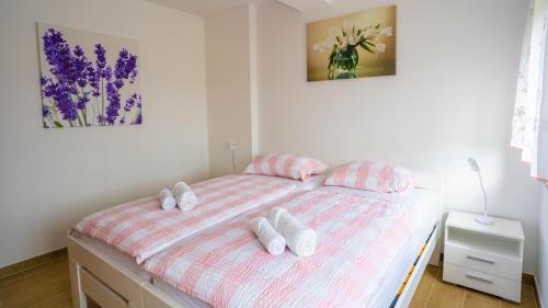 1 dormitorio con 1 cama con 3 almohadas en Apartma Tri oljke, en Dobrovo