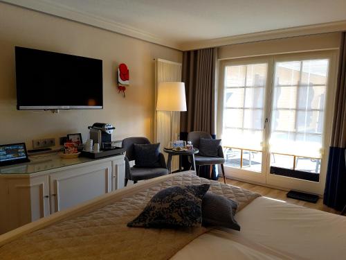 a hotel room with a bed and a television at Bio- und Wellnesshotel Alpenblick in Höchenschwand