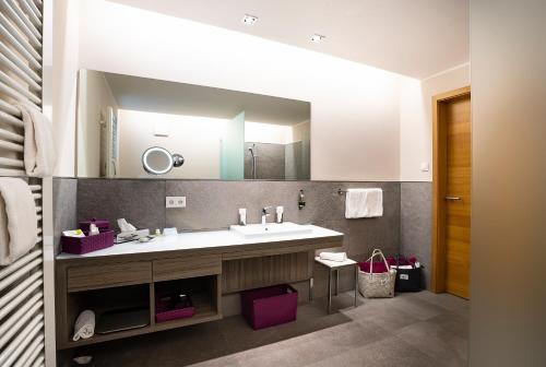 a bathroom with a sink and a large mirror at Bio- und Wellnesshotel Alpenblick in Höchenschwand