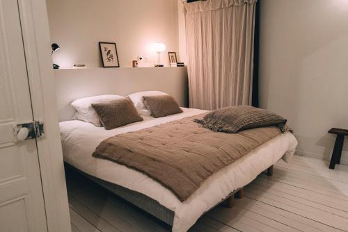 a bedroom with a bed with two pillows on it at Le Citron in Veules-les-Roses