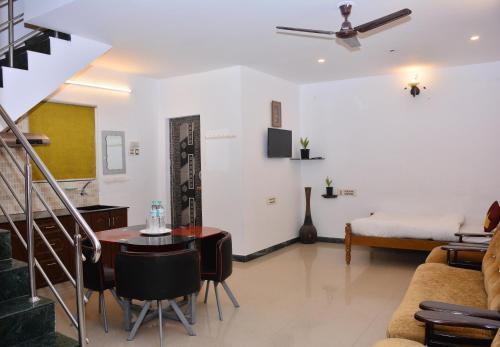 uma sala de estar com uma mesa e um sofá em TGT Holidays Yercaud em Yercaud