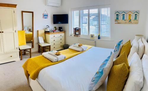 a bedroom with a large bed with towels on it at Avon Beach Bed & Breakfast in Christchurch