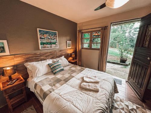 a bedroom with a bed with two towels on it at Pousada Santuário Acalanto in São Roque