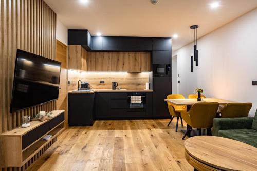 a kitchen and living room with a table and a dining room at Apartmán Nicole in Tale