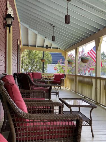 a screened in porch with chairs and a table at Central House Inn in Bar Harbor