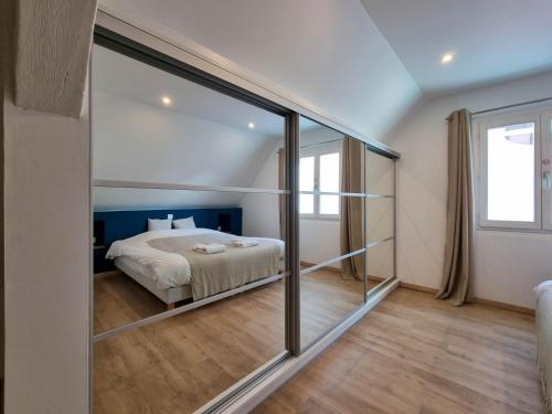 - une chambre avec un lit et un grand miroir dans l'établissement Travel Homes - NewGate 3, elegant, heart of Colmar, à Colmar