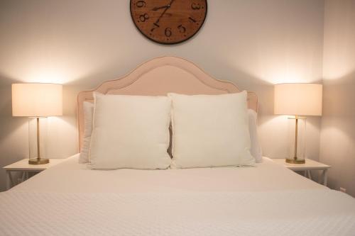 a bed with pillows and a clock on the wall at Douglas On Third in McMinnville