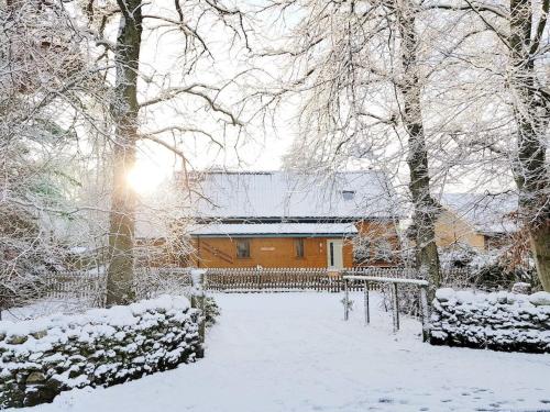 een huis is bedekt met sneeuw met bomen bij Baltinna East - by Where Stags Roar in Newtonmore