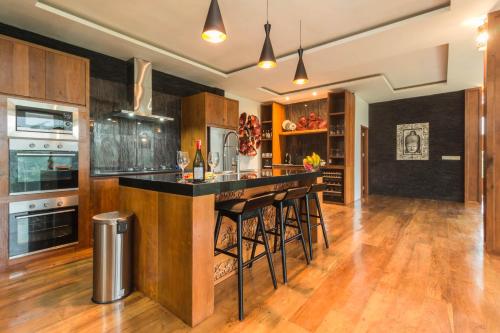 a kitchen with a bar with stools in it at Masakali Retreat in Ubud