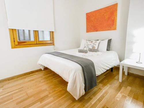 una camera bianca con letto e pavimento in legno di Casa del Nuncio a Toledo