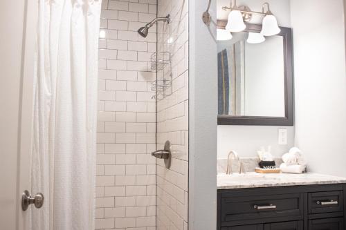 a bathroom with a shower with a sink and a mirror at Douglas On Third in McMinnville
