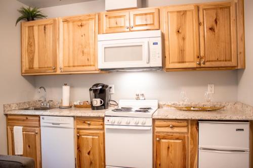 a kitchen with white appliances and wooden cabinets at Douglas On Third in McMinnville