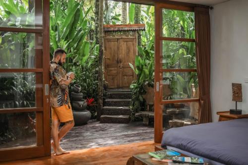a man standing in a room with a door open at Masakali Retreat in Ubud